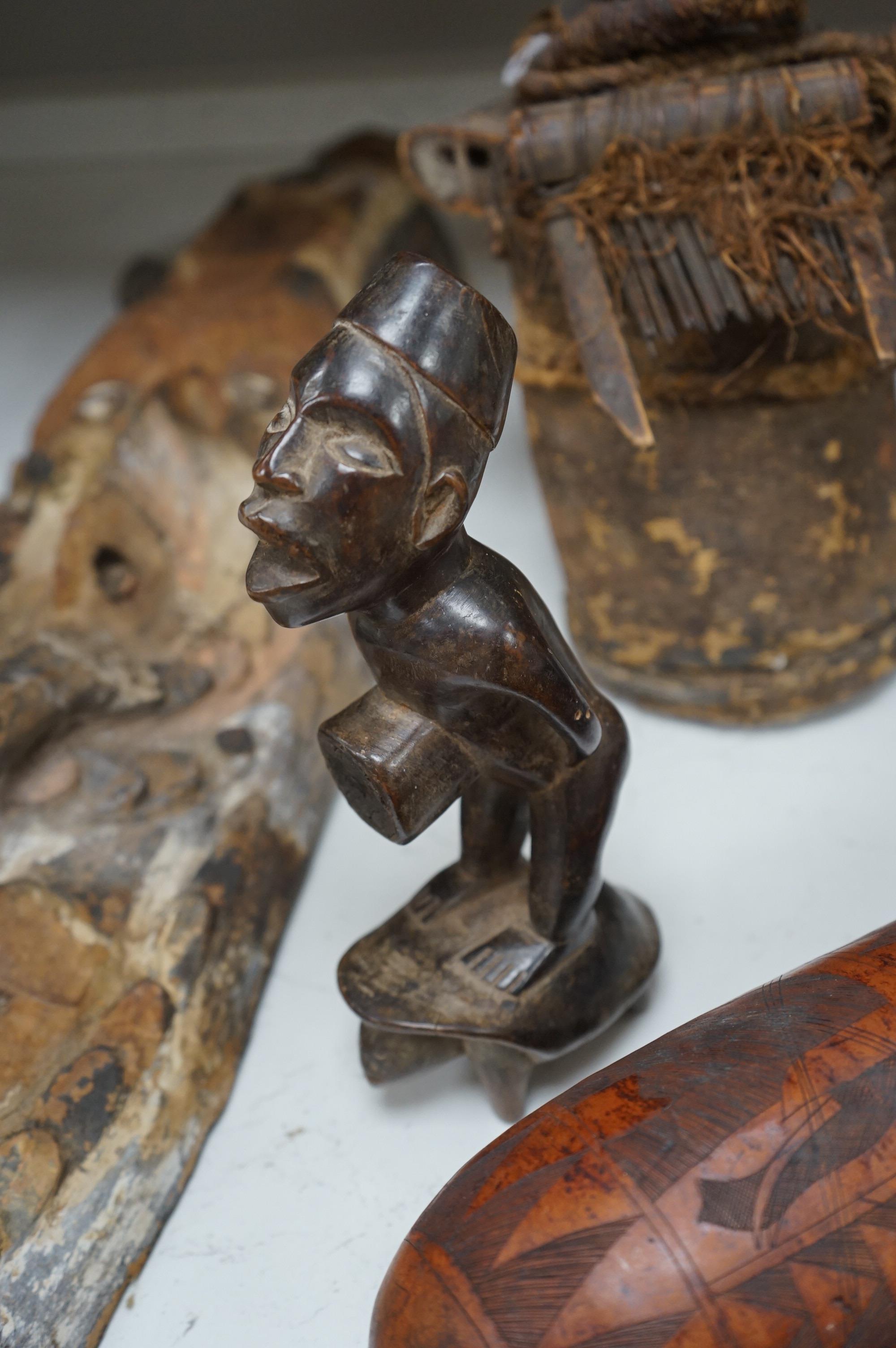 A group of African tribal artefacts, including a stool, a large painted carved mask, a carved gourd container and three carved figures, mask 76cm high. Condition- fair to good